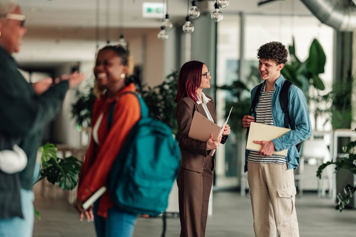 Diverse group of students and staff interacting in a modern university setting, fostering collaboration and learning